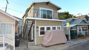 Une maison à deux étages avec un balcon, un abri pour voiture et un panneau indiquant « Ralentir, enfants dans les environs ».