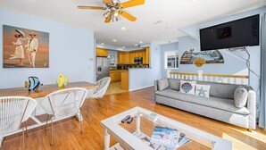 A modern living room with a sofa, white chairs, a coffee table, and a ceiling fan. - 217BA: Lovely 3 bdrm, 2.5 Bath, Ocean Views, Wifi (Avalon)