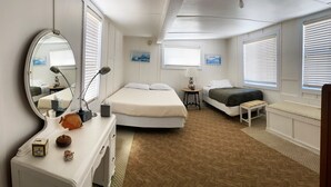 A bedroom with a bed, bedside table, lamp, and a dresser with decorative items. - 337CA: Charming 2-bdr Avalon cottage on the flats (Avalon)