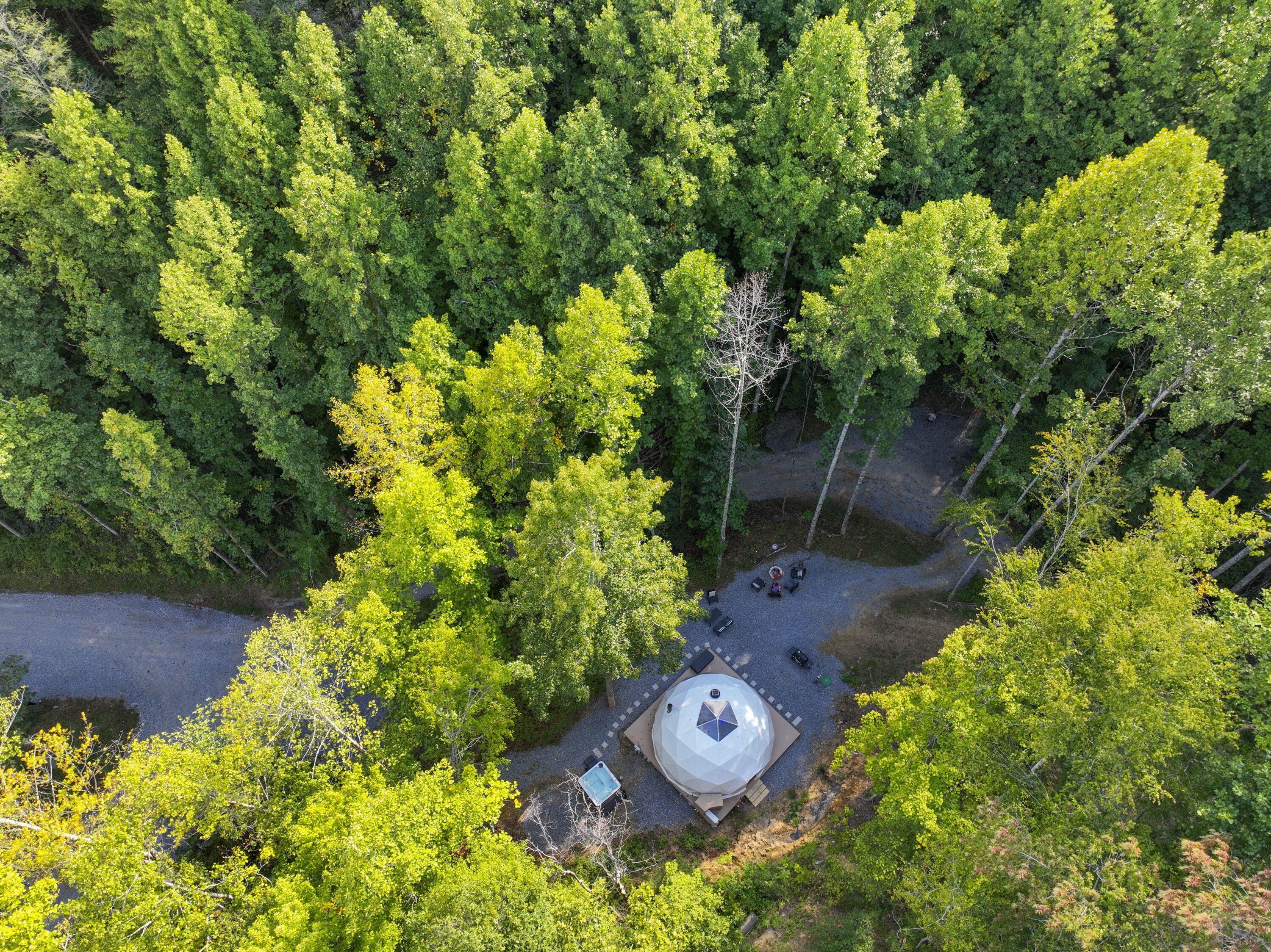 Vue aérienne d’une zone boisée avec un bâtiment circulaire entouré d’arbres.