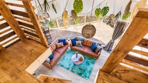 A wooden deck with a sofa set and hanging plants. - ✨🥂 Glamping Dome with Full Bath, Kitchen, Fire Pit, & Grill (Cosby)