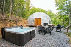 A cozy outdoor setting with a hot tub, wooden deck, and a dome tent. - 🌙💃 Moon Dance Glamping Dome w/Hot Tub, Bath, Kitchen (Cosby)