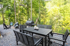 An outdoor seating area with a table and chairs, surrounded by trees. - 🌙💃 Moon Dance Glamping Dome w/Hot Tub, Bath, Kitchen (Cosby)