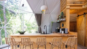 Une cuisine moderne dotée d’un îlot central, de tabourets de bar et d’une grande fenêtre.