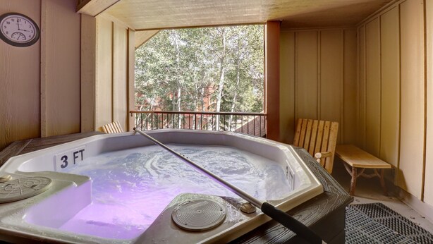 A hot tub with a wooden bench and a clock on the wall. - 101 Streamside Lane 2 Bedroom Condo by RedAwning (Frisco)
