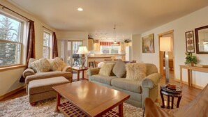 A cozy living room with a sofa, armchair, and coffee table. There is a dining area with a table and chairs. - 101 Streamside Lane 2 Bedroom Condo by RedAwning (Frisco)