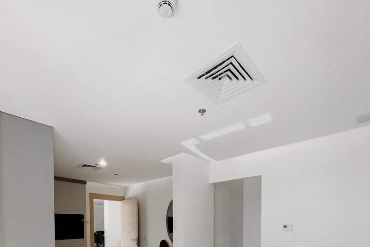 Una habitación de hotel moderna con una cama grande, un baño y una kitchenette.