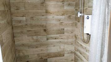 Een douche, een haardroger, handdoeken, toiletpapier