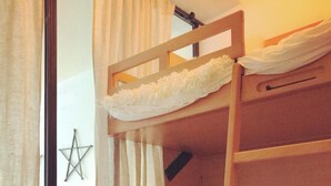 A bunk bed in a room with a window, curtains, and a star decoration on the wall. - South-facing apartment in resort center (Isola 2000)