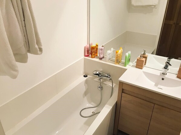 A modern bathroom with a bathtub, a sink, and a mirror.