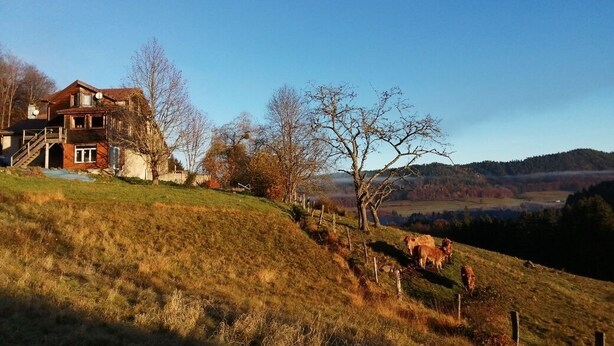Una casa en una colina con vistas despejadas del paisaje circundante.