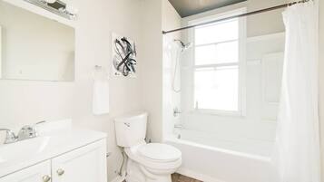 Bathtub, hair dryer, towels, shampoo