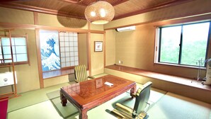 A traditional Japanese room with tatami flooring, a wooden table, chairs, a shoji screen, and a large window. - Hakone Rose Hill Private Duplex Villa (Hakone)