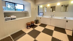 A modern bathroom with a window, two sinks, a mirror, and a small window shelf. - Hakone Rose Hill Private Duplex Villa (Hakone)