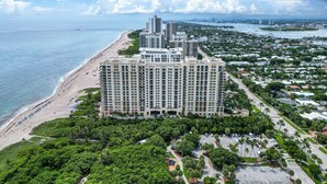 A high-rise hotel with multiple floors, a beachfront, and a parking lot.