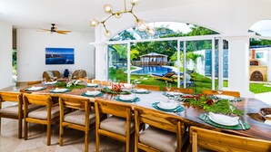 A dining area with a large table set for six, surrounded by wooden chairs with cushioned seats. - Spacious Villa w/ Private Pool – Ideal for Groups, Steps to Tamarindo Beach (Tamarindo)