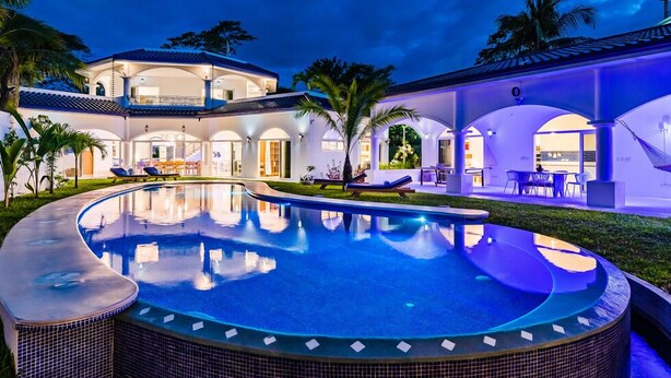 A luxurious resort with a large swimming pool, multiple lounge areas, and a well-lit outdoor space. - Spacious Villa w/ Private Pool – Ideal for Groups, Steps to Tamarindo Beach (Tamarindo)