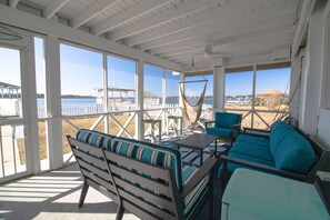 A covered outdoor seating area with a view of a dock and water.