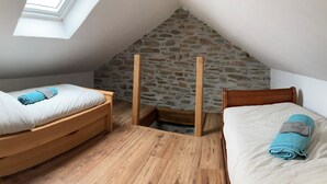 A small, cozy room with two wooden beds, a stone wall, and a skylight. - Superb character house entirely renovated for your pleasure. (Monthermé)