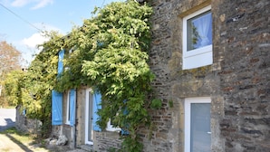 A rustic stone building with a window and a door, partially covered by ivy. - Superb character house entirely renovated for your pleasure. (Monthermé)