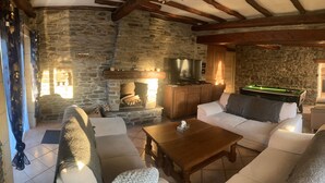 A cozy room with stone walls, a fireplace, a sofa, a coffee table, and a pool table. - Superb character house entirely renovated for your pleasure. (Monthermé)