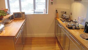 A compact kitchen with wooden countertops, a microwave, a toaster, and a coffee maker. - 2 bedroom accommodation in Bakewell (Bakewell)