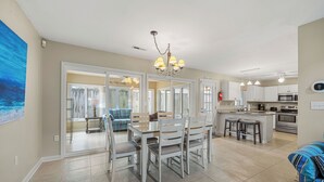 Una cocina amplia con comedor, una isla grande y una sala de estar con sofá y sillones.