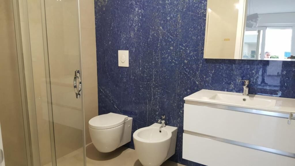 Une salle de bain dotée d’une douche à parois de verre, de toilettes, d’un bidet et d’un meuble-lavabo avec un miroir.