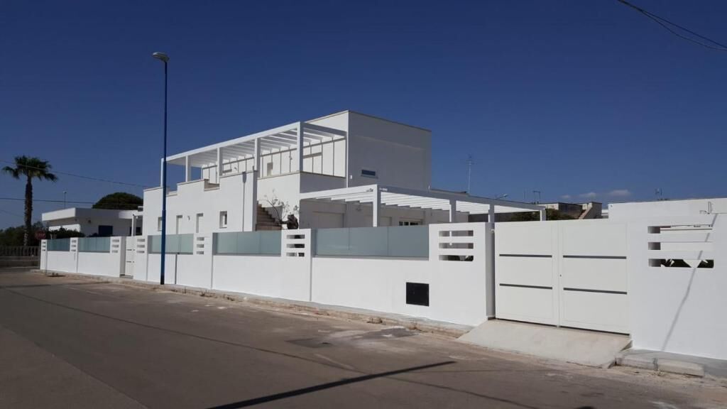 A modern building with a flat roof, large windows, and a white exterior.
