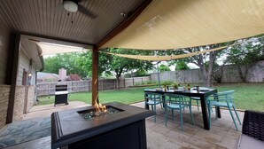 An outdoor patio with a grill, a fire pit, and a table with chairs. - Ranch Acres Expo-Heart of Tulsa (Tulsa)