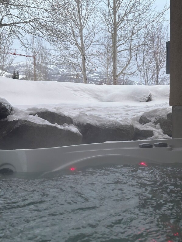 A hot tub with a view of a snowy landscape and bare trees. - Ski house with space and charm (Heber City)