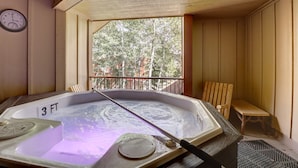 Jacuzzi amb una bassa de fusta i un rellotge a la paret.