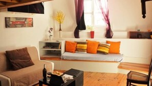 Uma sala de estar aconchegante com um sofá, uma mesa de centro e uma estante de livros.