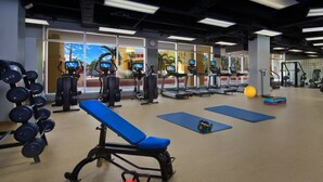 Une salle de sport équipée de matériel d’exercice, de tapis de course et d’appareils de musculation.