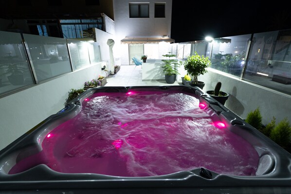 A hot tub with pink lighting, surrounded by potted plants and a small outdoor seating area. - Accommodations with a spa. Free Wi-Fi. 0.3 km from the beach. We accept children over the age of 12 (Corralejo)