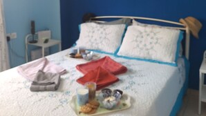 Un dormitorio con cama, almohadas, una mesita de noche y una pared con diseño de noche estrellada.