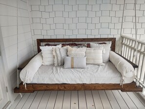 A bed with a wooden headboard, white bedding, and multiple pillows.