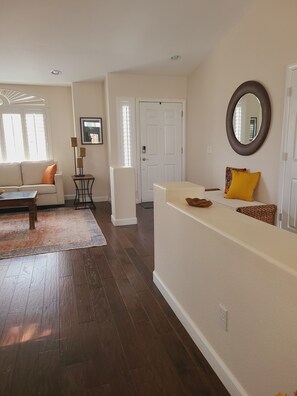 A living room with a sofa, a coffee table, a rug, and a wooden floor. - Las Vegas Pool Home Near Strip /Airport Holiday Dates Open & Discount Available
 (Las Vegas)