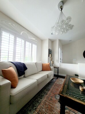 A living room with a sofa, a coffee table, a chandelier, and a patterned rug. - Las Vegas Pool Home Near Strip /Airport Holiday Dates Open & Discount Available
 (Las Vegas)