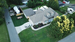 An aerial view of a residential area with houses, a driveway, and a green lawn. - EXCLUSIVE LARGE 2 BEDROOM SUITE W/THEATER ROOM + KITCHEN  (Cleveland)