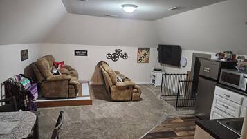 Relax in this cozy space with a two-seater recliner, kitchenette, and flat-screen TV.