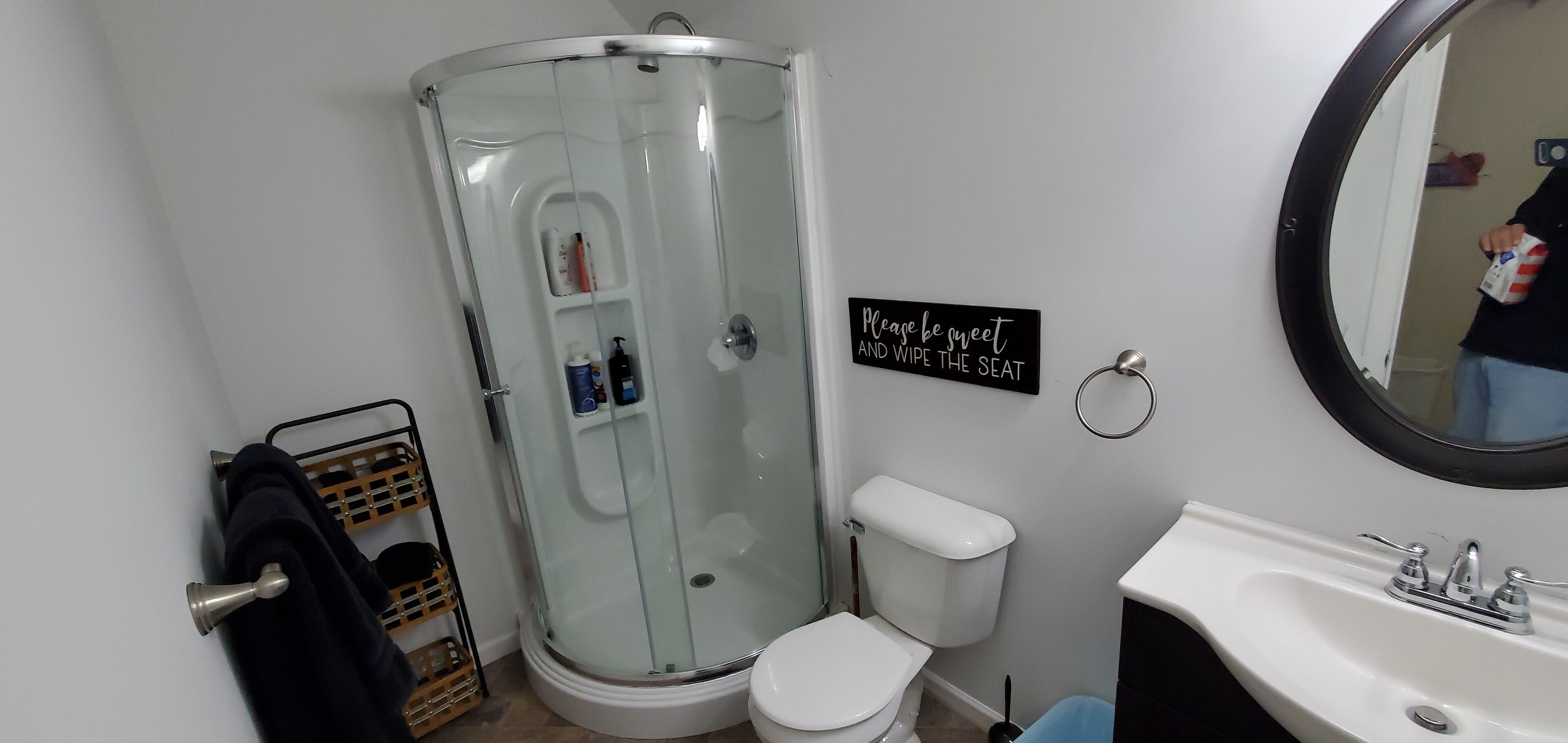 Ein Badezimmer mit Duschkabine, Toilette, Waschbecken und einem Schild mit der Aufschrift 'Bitte sauber machen.'