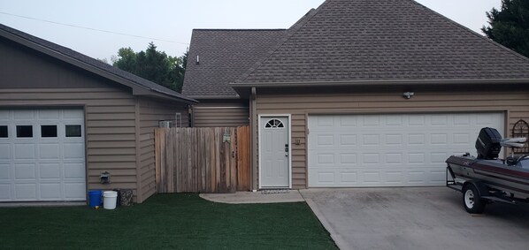 A residential garage with a white door and a boat trailer parked outside.