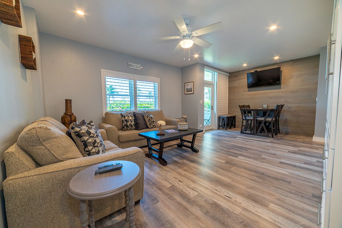 A spacious living area with a sofa, coffee table, and a dining table.