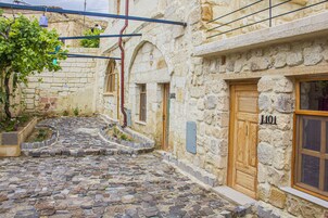 Un edificio de piedra con una puerta de madera marcada con 