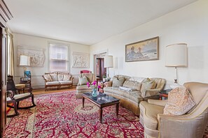 A living room with a patterned rug, a sofa, a chair, and a coffee table.
