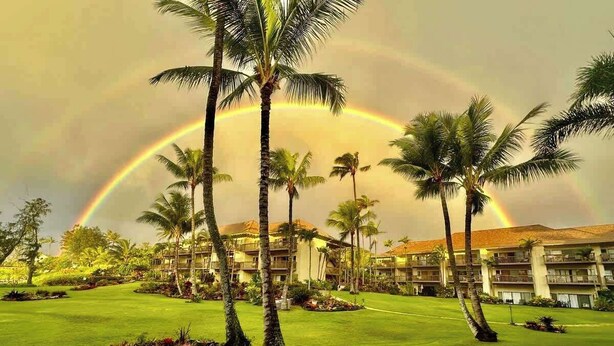 A resort with palm trees, a lawn, and a building with balconies. - Lae Nani 313, Great View Ground Floor (Kapaʻa)