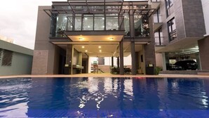 Ein modernes Gebäude mit Schwimmbecken davor.
