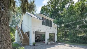 Une maison à deux étages dotée d’un porche abrité, d’un garage et d’un escalier menant à l’étage supérieur.