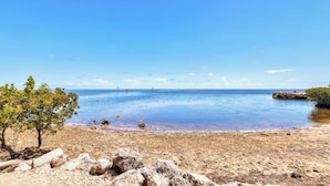 A beach with calm water, a clear sky, and a few trees. - Oceanside Anglers Reef Home+Beach, Pool and Kayaks (Islamorada)